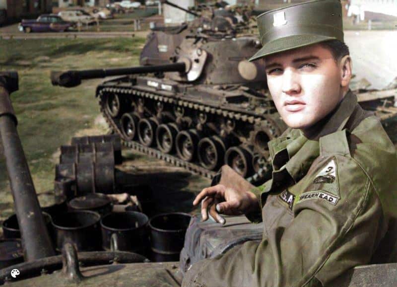 Elvis poserar nära en tank i Tyskland