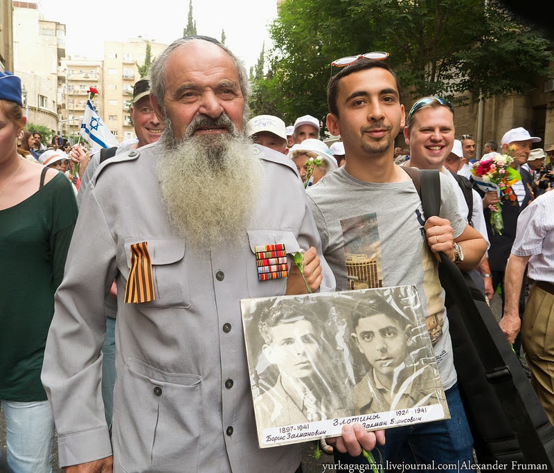 Roman lleva una fotografía de su padre y su hermano en una marcha del Día de la Victoria en Jerusalén, mayo de 2013