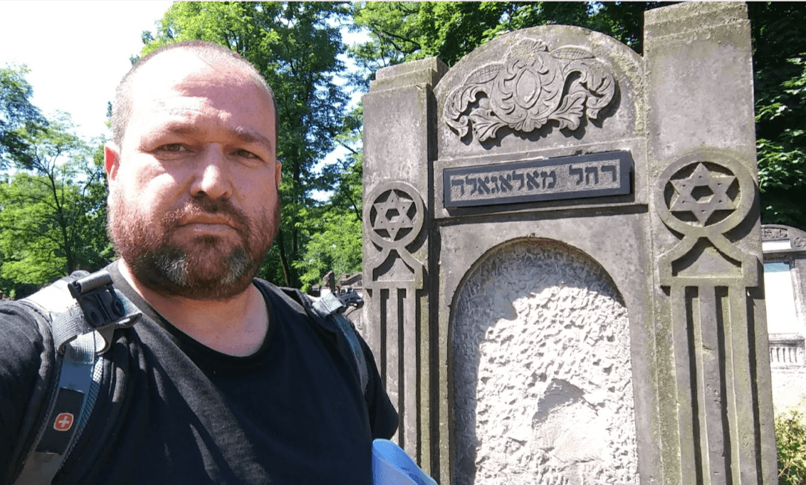 Dudi pictured next to that same gravestone on a trip to Lodz
