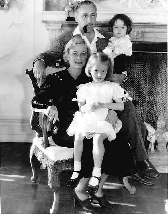John Barrymore and family in 1934. Standing: John Barrymore holding John Drew Barrymore. Seated: Dolores Costello Barrymore with Dolores Barrymore on her lap.