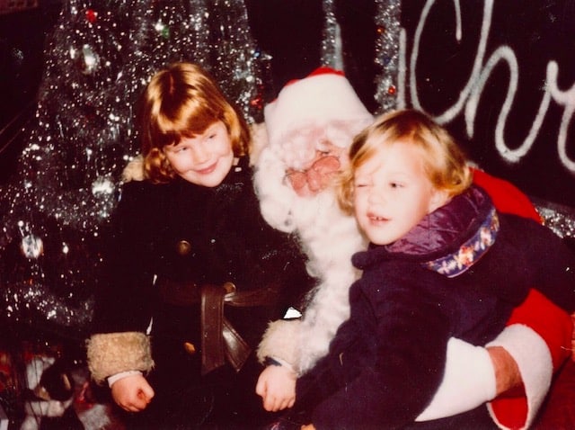 Et par søde søstre med julemanden. Foto forbedret og repareret og farverne restaureret af MyHeritage
