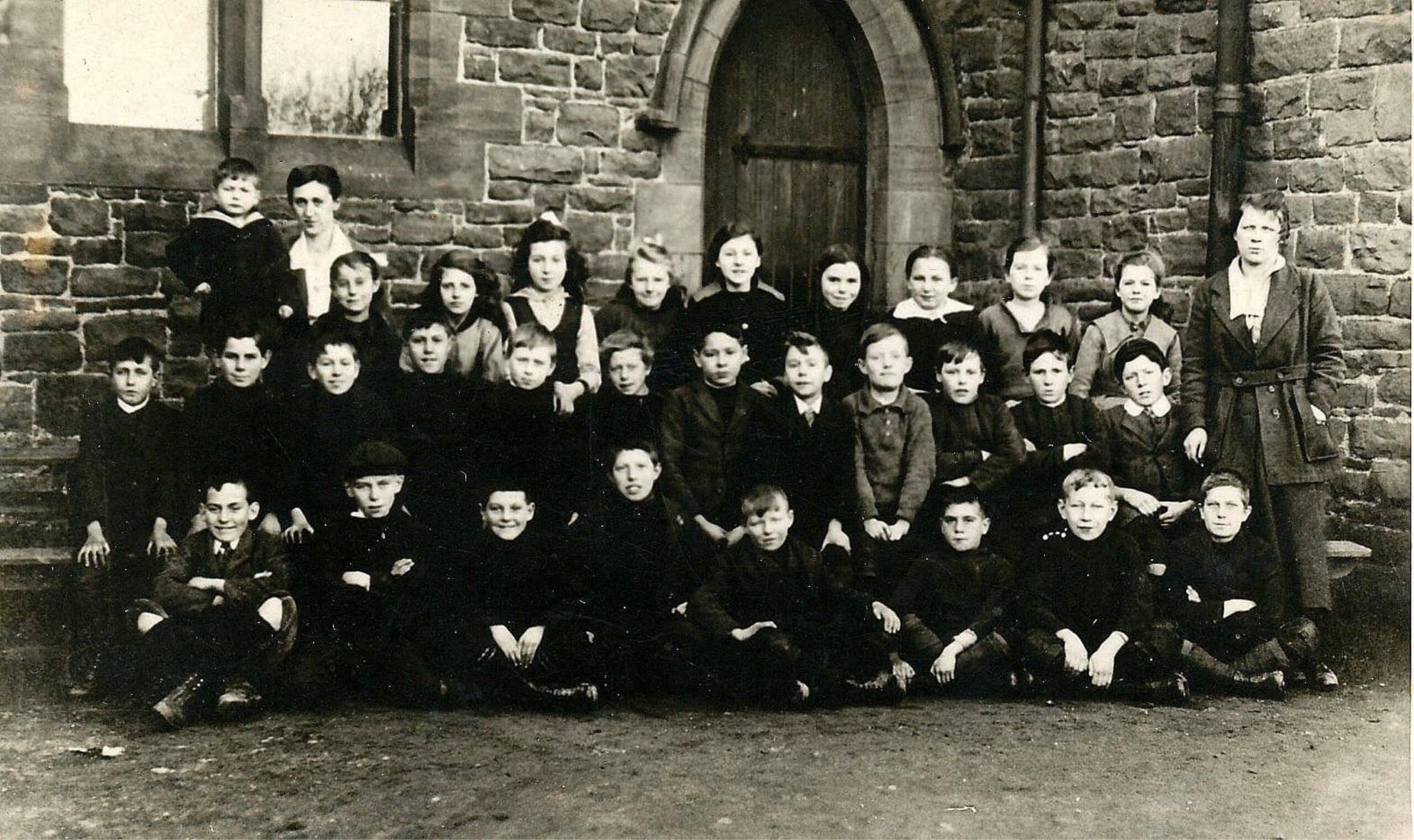 Mary Dawson (geborene Curren, stehend, links) in der Church of England School in Newbiggin-by-the-Sea. Foto koloriert und verbessert von MyHeritage