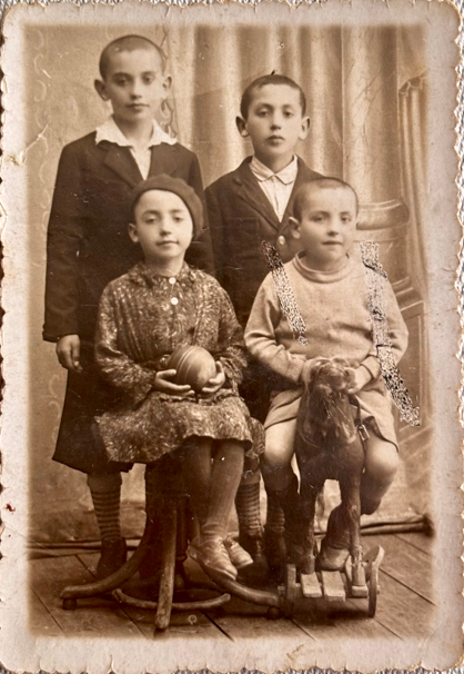 Simha (bottom right) with his siblings as children. Photo enhanced and colorized by MyHeritage