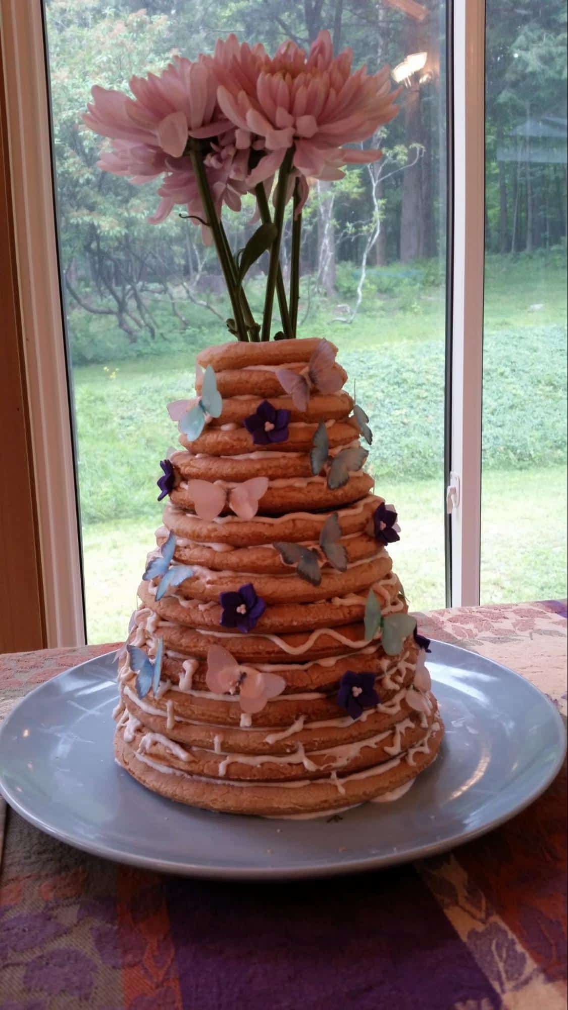 Photo of kransekeke: tall layered cake decorated with flowers and butterflies